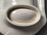 a white plate with a spoon on it on a table