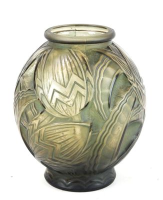 un vase vert orné d'un motif sur fond blanc