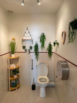 des toilettes dans une salle de bains avec des plantes accrochées au mur