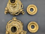 three antique brass candlesticks and a candle holder on a table