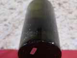 une bouteille de vin posée sur une surface rouge