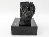 black and white photograph of a sculpture of a hand on a black base