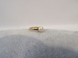 a close up of a ring with a pearl on it