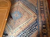 un tapis posé à même le sol, à côté d'une table en bois