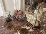 a statue of a man sitting on top of a table next to other items