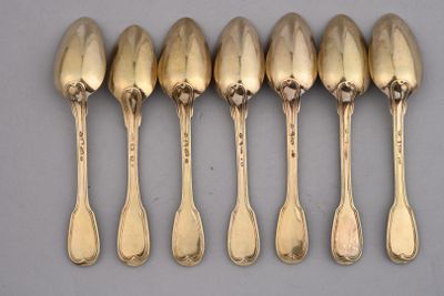 six silver spoons are lined up in a row on a table