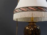 une lampe posée sur une table, avec un abat-jour blanc