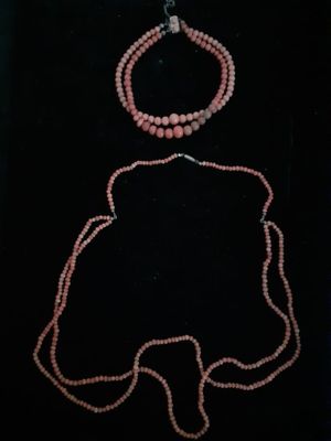 a pink beaded necklace and bracelet set on a black background