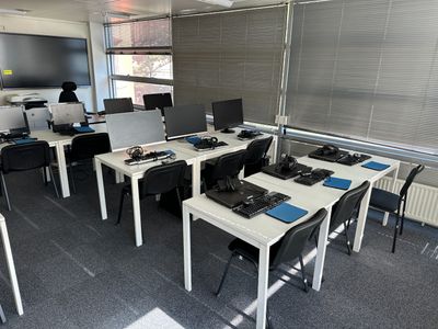 une pièce où se trouvent plusieurs ordinateurs et bureaux