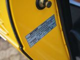 a close up of a yellow car door with a sticker on it