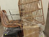 une chaise en osier posée sur une pile de cartons