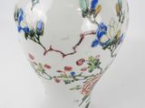 a white vase with blue and red flowers on it