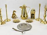 a lot of brass objects on a white surface
