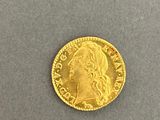 a close up of a gold coin on a gray surface