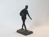 une statue représentant un homme debout sur un socle