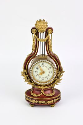 a clock that is sitting on a stand on a white surface