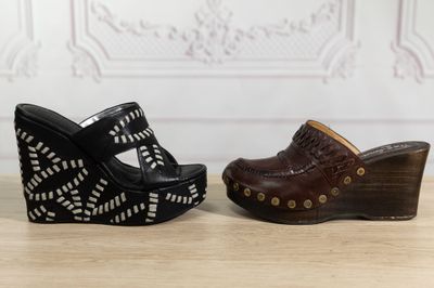 pair of black and brown wedged shoes on a wooden table