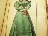an open book with a drawing of a woman in a green dress and hat