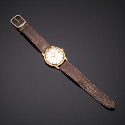 une montre-bracelet en or avec un bracelet en cuir marron et un cadran blanc