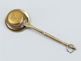 an antique brass spoon with a handle and a hook on it