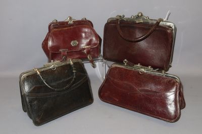 four pieces of leather purses are lined up on a white surface