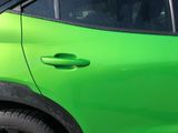 a green car that is parked on the side of the street