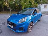 a blue car parked in a parking lot next to a house