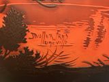 a red vase with a picture of a lake and trees on it