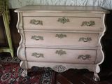 a pink dresser with gold handles in a room