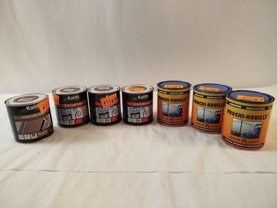 un lot de pots de peinture posés sur une surface blanche
