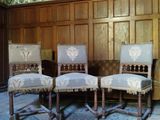 trois chaises dans une pièce dont les murs sont recouverts de boiseries