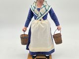 figurine of a woman in a blue dress holding a bucket and a basket