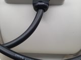 a black cable connected to an electrical outlet on a white wall