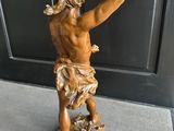 statue en bronze représentant un homme tenant une épée posée sur une table