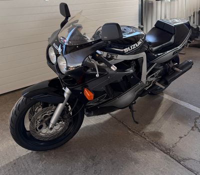 a black motorcycle parked in a garage next to a garage door