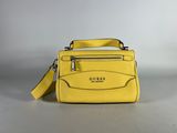 a close up of a yellow purse on a white surface