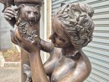 a statue of a woman holding a bird on a pole