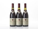 three bottles of wine are lined up on a white surface