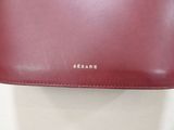 the red leather wallet is sitting on a white surface