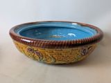 a blue bowl with a brown rim sitting on a table