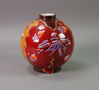 un vase rouge orné d'un motif floral