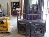 a forklift in a warehouse with other equipment in the background