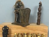 une statue représentant un homme assis sur une étagère en bois