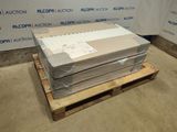 une pile de cartons posée sur une palette devant un mur