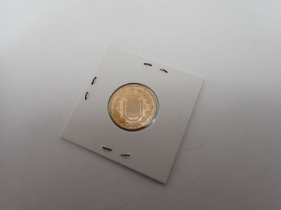 gros plan d'une pièce d'or sur une surface blanche