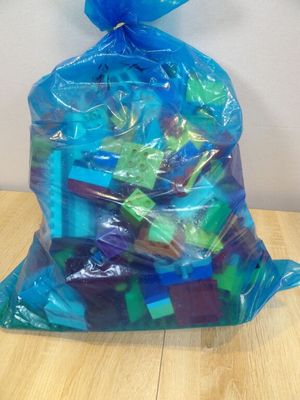 un sac de jouets en plastique posé sur une table en bois
