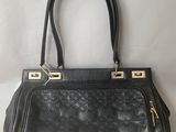 a black handbag with gold hardware on the handle