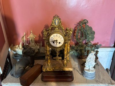une horloge posée sur une table dans une pièce aux murs roses