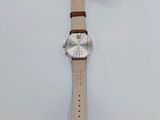 an image of a watch on a white surface with a tag on it