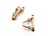 a pair of gold cufflinks on a white background